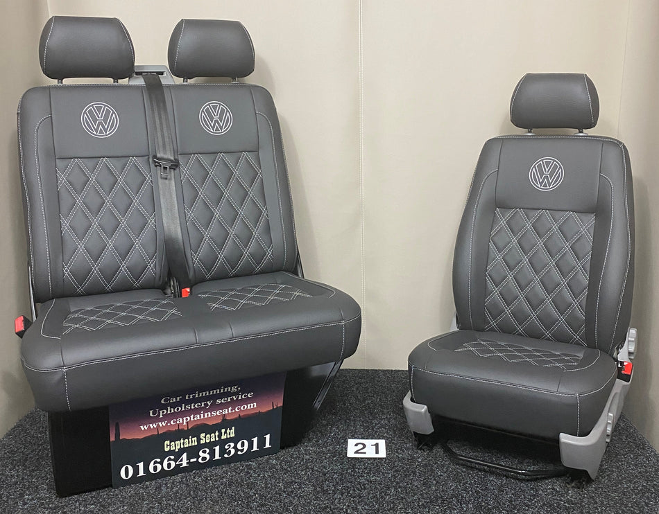 VW Factory T5 T6 Front Seats, full view of black leatherette with light grey Bentley cross stitching, light grey VW logo on headrests, and light grey plastic trim.