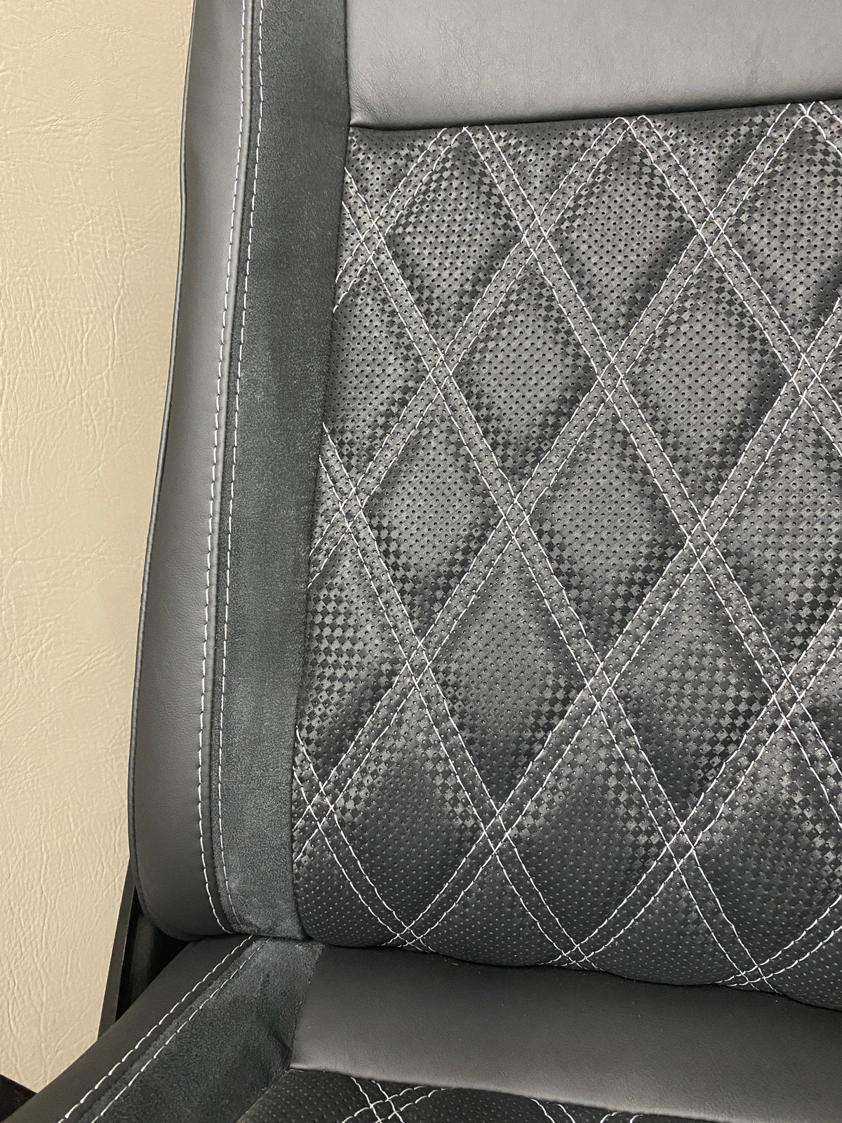 VW Factory T5 T6 seat close-up of   black real leather and carbon perforated centre panel with black Alcantara insert featuring light grey Bentley stitching.