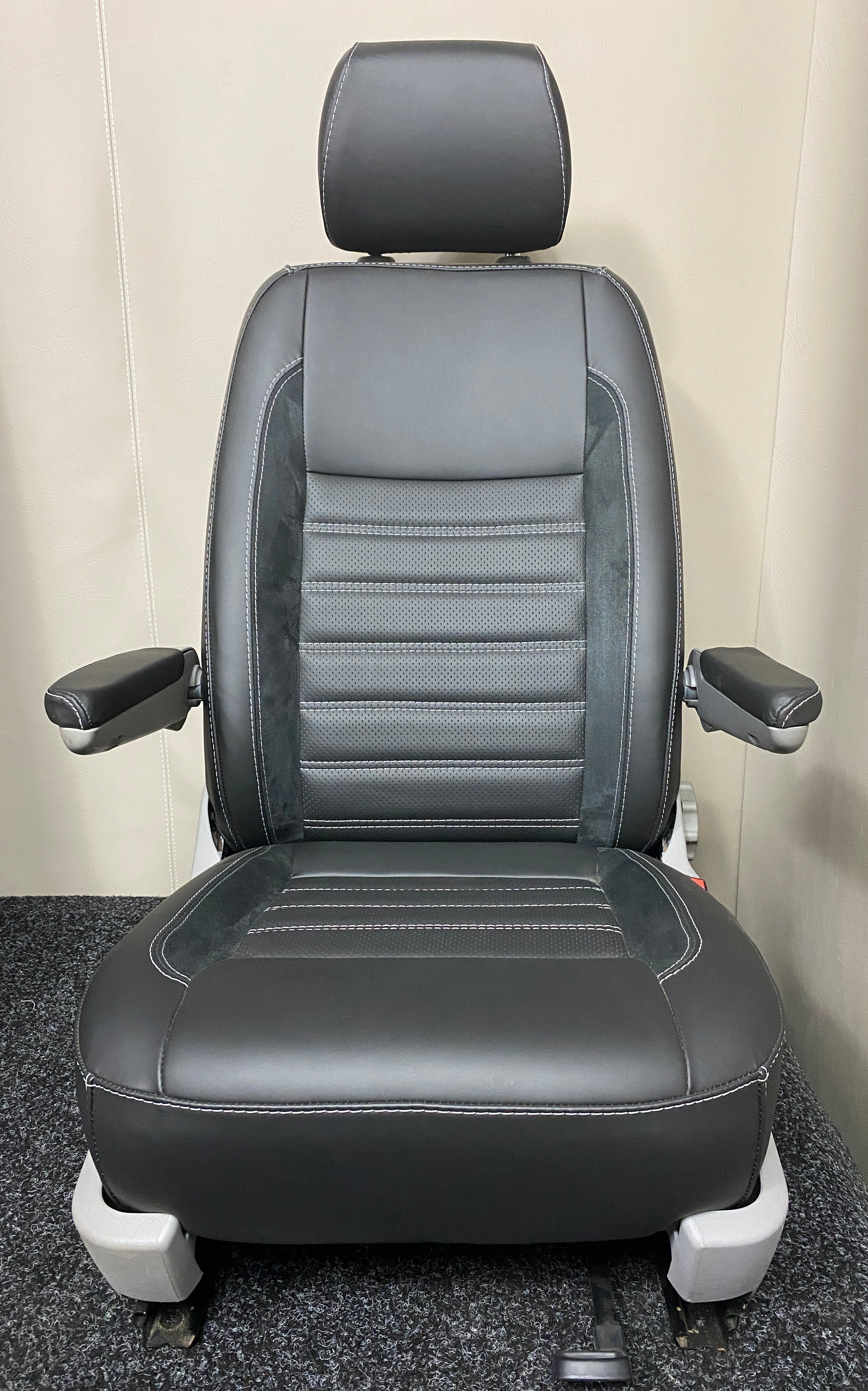 VW Factory T5 T6 driver seat in black real leather with perforated centre panel, Alcantara faux suede inserts, horizontal wide cross-stitching, and dual armrests.