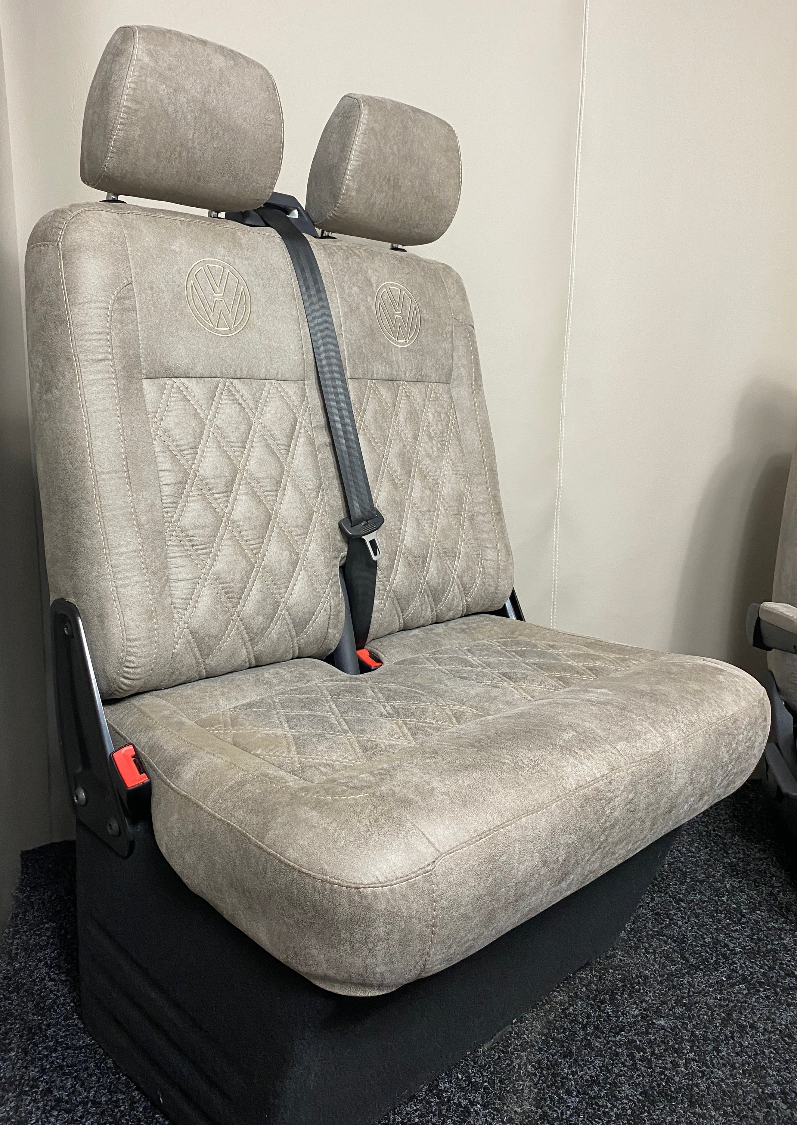 VW Factory T5 T6 Passenger Seats in beige faux suede with cream Bentley cross stitching and black VW logos on the upper backrests.