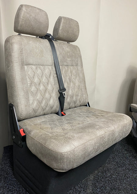 VW Factory T5 T6 Passenger Seats in beige faux suede with cream Bentley cross stitching and black VW logos on the upper backrests.
