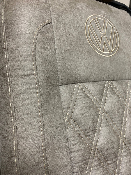 VW Factory Front Seat T5 T6 close-up of the faux suede upholstery with cream Bentley stitching and embroidered VW logo.