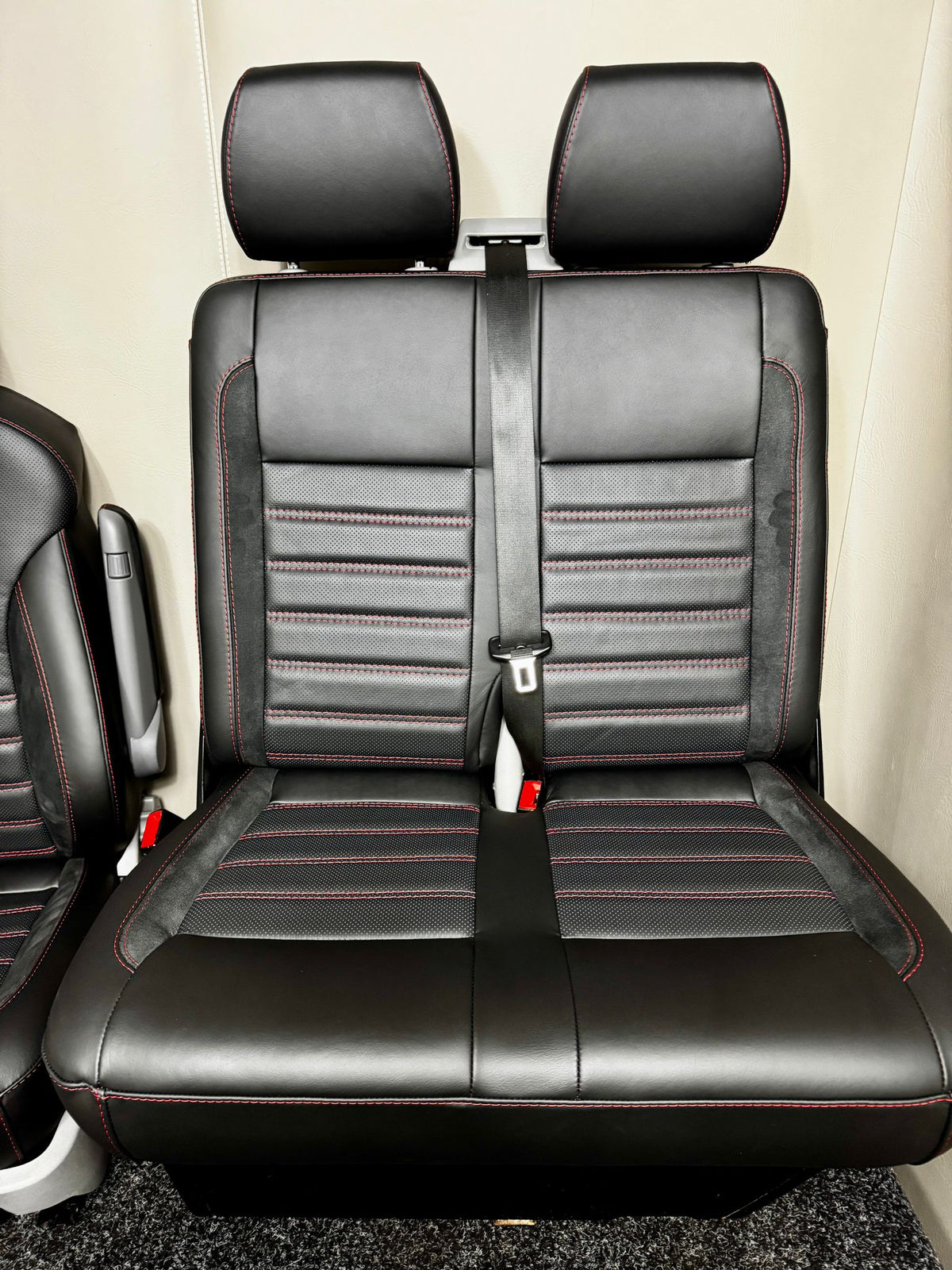 VW Factory T5 T6 front passenger seats with an integrated seatbelt, black Nappa leather, perforated centre panel, Alcantara inserts, and red stitching.