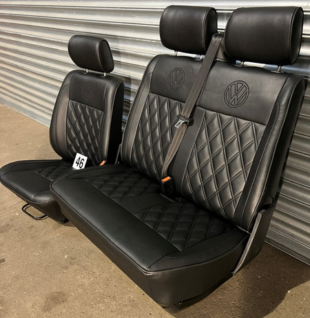 VW T4 front seats, side-angled view, showing, black leatherette, black Bentley stitch pattern, black VW logos, and seatbelt.