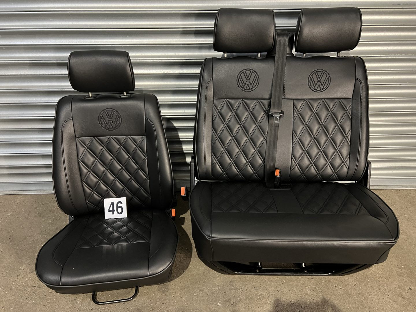 VW T4 front seats, front view showing black leatherette with black Bentley pattern, piping detail, and VW logo on headrests.