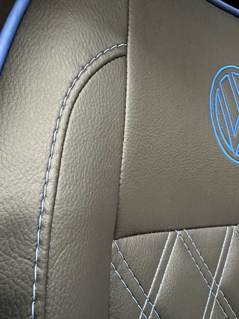 VW T5 T6 front seat, close up of the backrest in black leatherette with blue stitching.