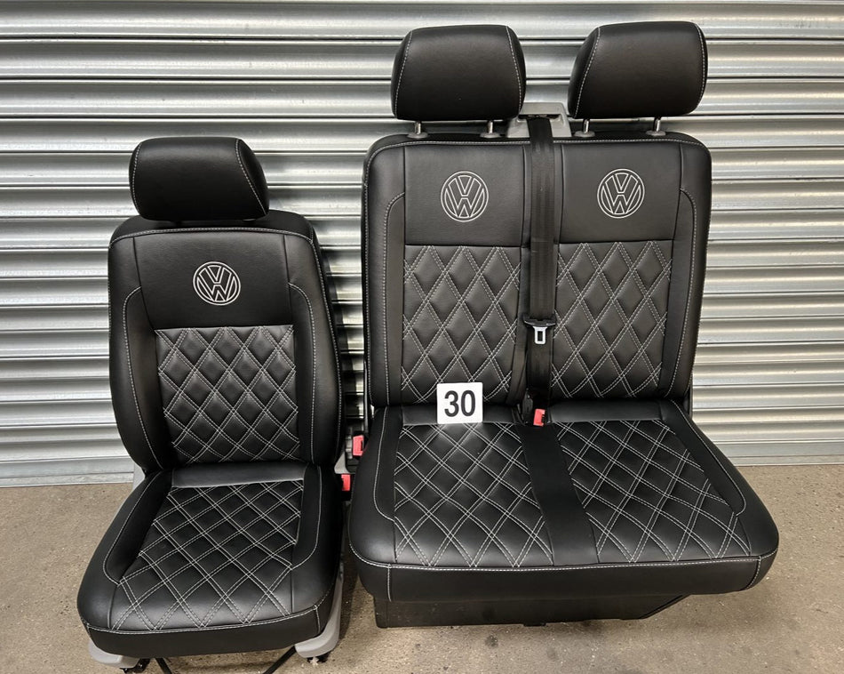 VW T5 T6 front seats in Black leatherette upholstery with grey cross stitching and VW logos.